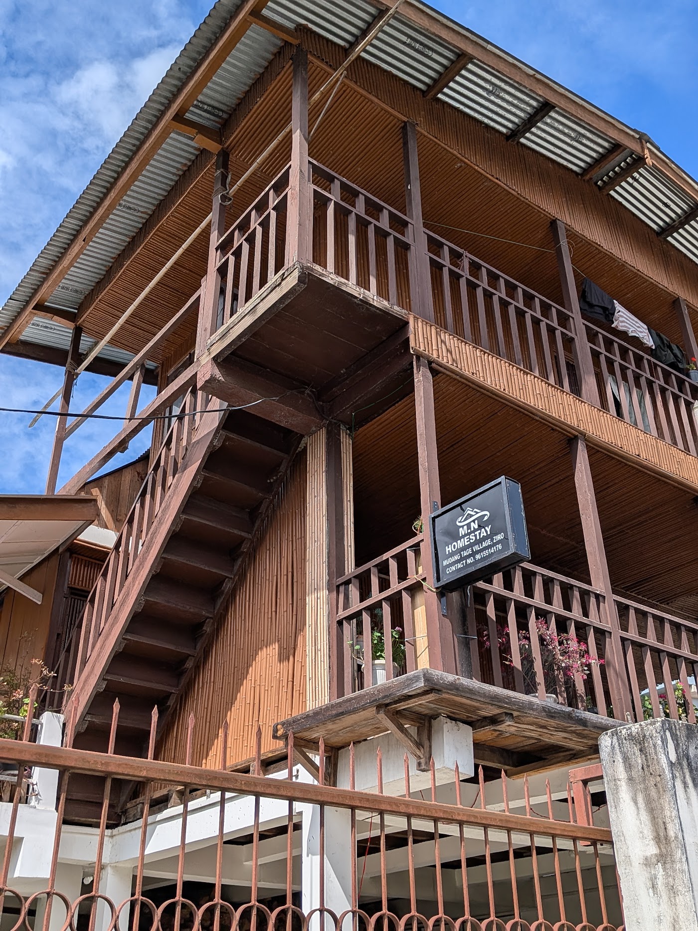The timber and bamboo front of M.N Homestay, with the house sign on the balcony